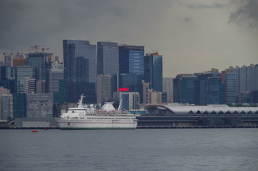 Classic casino cruiseship in front of Kai Tak cruise terminal and Kai Tak Kowloon Bay skyline