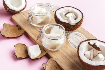 Broken coconut pieces on bright pink background, top view, copy space