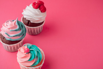 Tasty cupcakes sweets on pink background close up