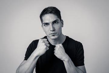 Young attractive man with an angry face in boxing stance ready to fight