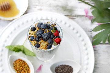 Yogurt with chia seeds, pollen and berries of wild strawberries