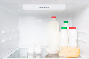 on a shelf in a white fridge, animal products, cream, milk, kefir, eggs, cottage cheese and cheese