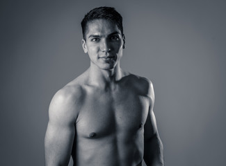 Fototapeta na wymiar Portrait of strong handsome Athletic man feeling good and happy isolated on neutral background