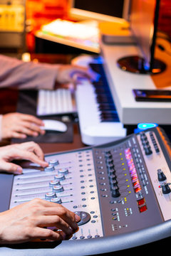 producer and sound engineer hands mixing, recording sound for movie score or advertising jingle in studio. recording, broadcasting, editing, music production concept