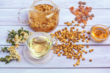 Healthy chamomile tea  in glass cup. Teapot, small honey jar