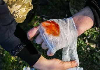 Man is putting bandage on bleeding wound. Injured hand. Tourist in the nature. Infection danger....