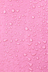 transparent water drops on a pink background