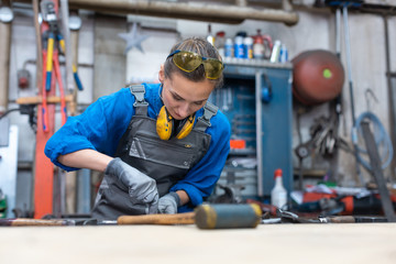 Woman metalworker marking piece of steel