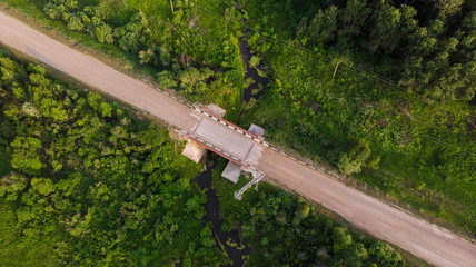 Aerial view. Rural road through  small bridge surrounded by picturesque vegetation