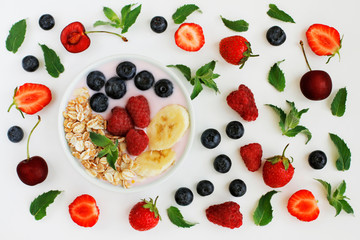 Healthy breakfast - oatmeal, yogurt, bananas, blueberries, raspberries and different berries on white background