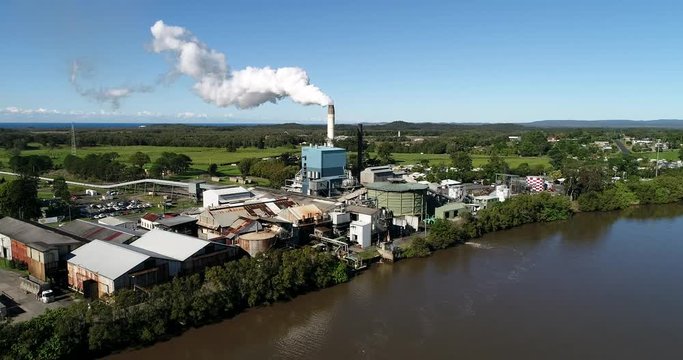 Broadwater Sugar mill food industry processing plant on shores of Richmond river surrounded by sugar cane fields and farms in Australia.