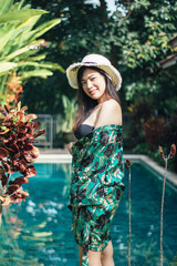 Pretty Asian woman is relaxing in the pool villa.