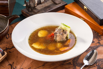 Meat soup with potatoes on old map background