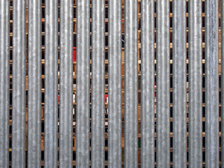 Obraz premium a vertical galvanized steel fence with wooden pallets in outdoor storage visible between the gaps