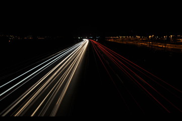 Fototapeta na wymiar Lichtspuren auf Autobahn neben Güterbahnhof