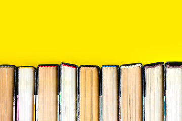 Stack of old books, textbooks on a yellow background, literature concept