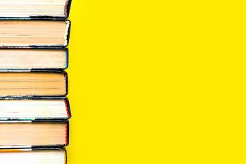 Stack of old books, textbooks on a yellow background, literature concept