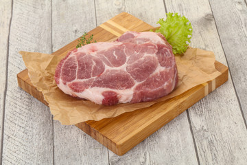 Raw pork steak over wooden board