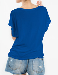 Woman wearing blue t-shirt and short rip jeans with copy space in back side isolated on white background