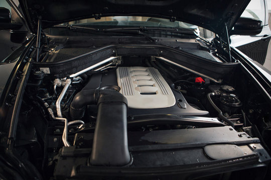 Car repair and cleaning concept - car engine close-up, wiping parts under the hood