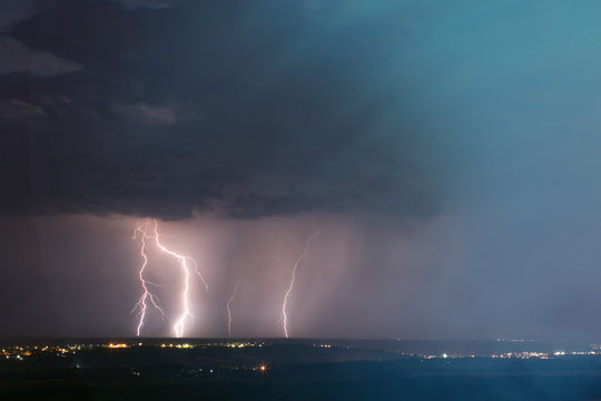 lightning storm over city. Lightning strike over dark blue sky in night city 