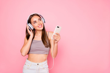 Portrait of cute curious lady looking up holding device wearing white denim jeans gray tank-top...