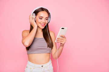 Portrait of lovely millennial holding device looking isolated over pink background