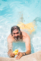 Senior man in his home swimming pool, enjoying the deserved retirement
