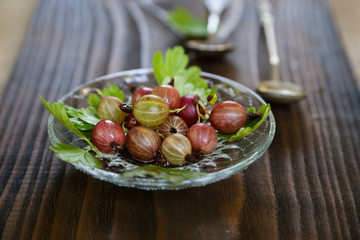 sweet fresh gooseberry berry in a bowl on dark background.