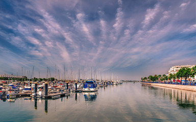 Yachts and boats in Ayamonte marina on a day with an impressive cloudscape reflecting in the water. Ayamonte is a border town next to Portugal in the province of Huelva.