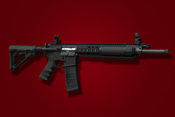Modern automatic rifle isolated on red background