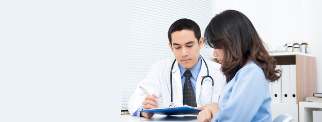 Woman patient consulting with Asian male doctor