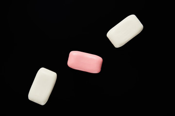 top view of pink and white soaps isolated on black