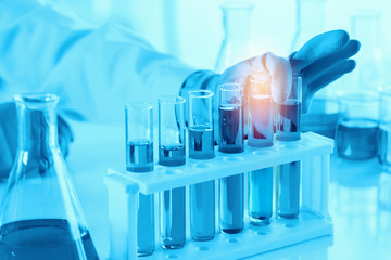 scientist with equipment and science experiments, laboratory glassware containing chemical liquid for research or analyzing a sample into test tube in laboratory