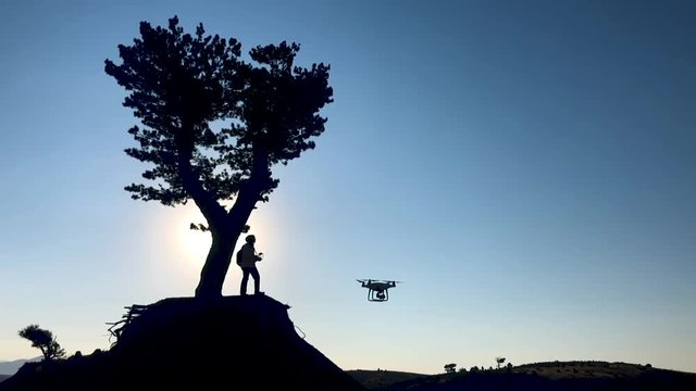 person using drone, aerial imaging vehicle in nature