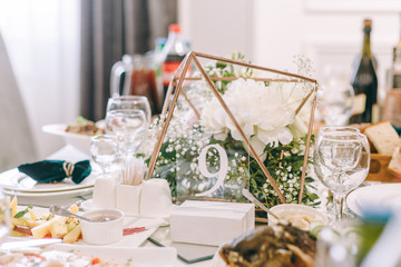 table number nine. wedding table. cured table. decor. wedding details. Interior of restaurant for wedding dinner, ready for guests. Decorated with floral arrangement. Dishes, wine glasses and napkins.