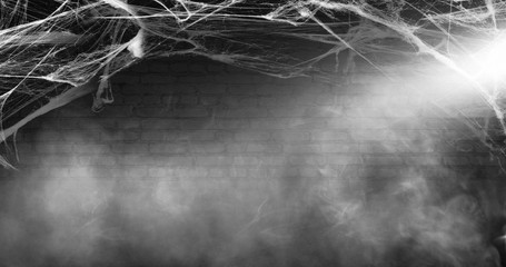 Halloween background. Background of old brick wall, cobweb, smoke, concrete floor