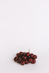 Grapes red with drops of water on white background.