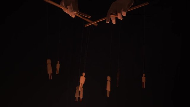 Puppet master and marionettes. Manipulations with the mind and actions of people concept