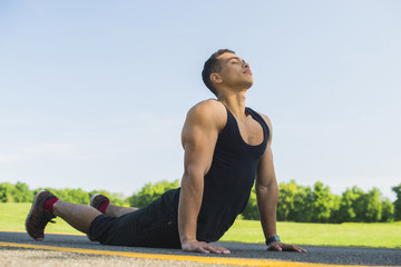 Athletic man practicing yoga outdoor