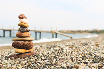 Pebble tower and a pier on the background on a beach at Assos, Canakkale. (Aegean Sea)