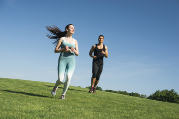 Man and woman running outdoor in a park