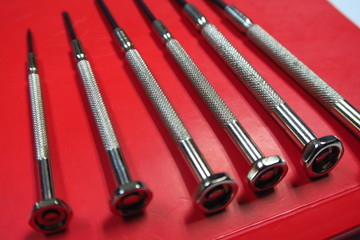 Set of screw driver tools on red background.