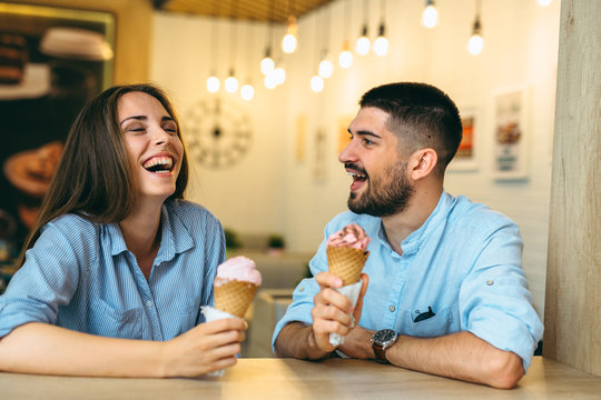 Friends Eating Ice Cream In Cones In Candy Shop