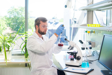 Scientist working in lab. Doctor making microbiology research. Laboratory tools: microscope, test tubes, equipment. Biotechnology, chemistry, bacteriology, virology, dna and health care.