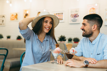 couple having fun eating ice cream in cafe