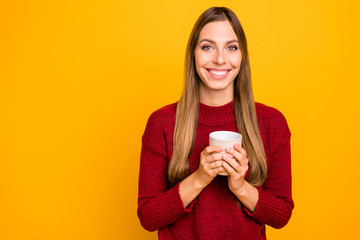 Pretty lady holding hot coffee glass overjoyed mood wear knitted pullover isolated yellow background