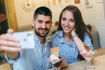 man taking picture with his girlfriend in cafe