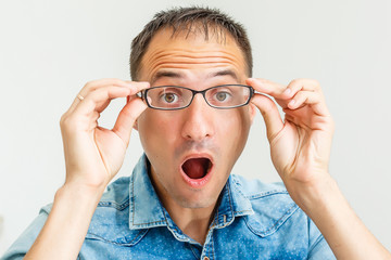 Closeup portrait of frustrated, mad angry nerdy young man with big glasses, screaming fists raised, isolated on white background. Negative emotions facial expressions feelings, body language