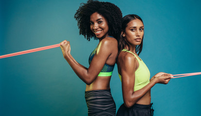 Two women doing exercises with resistance band